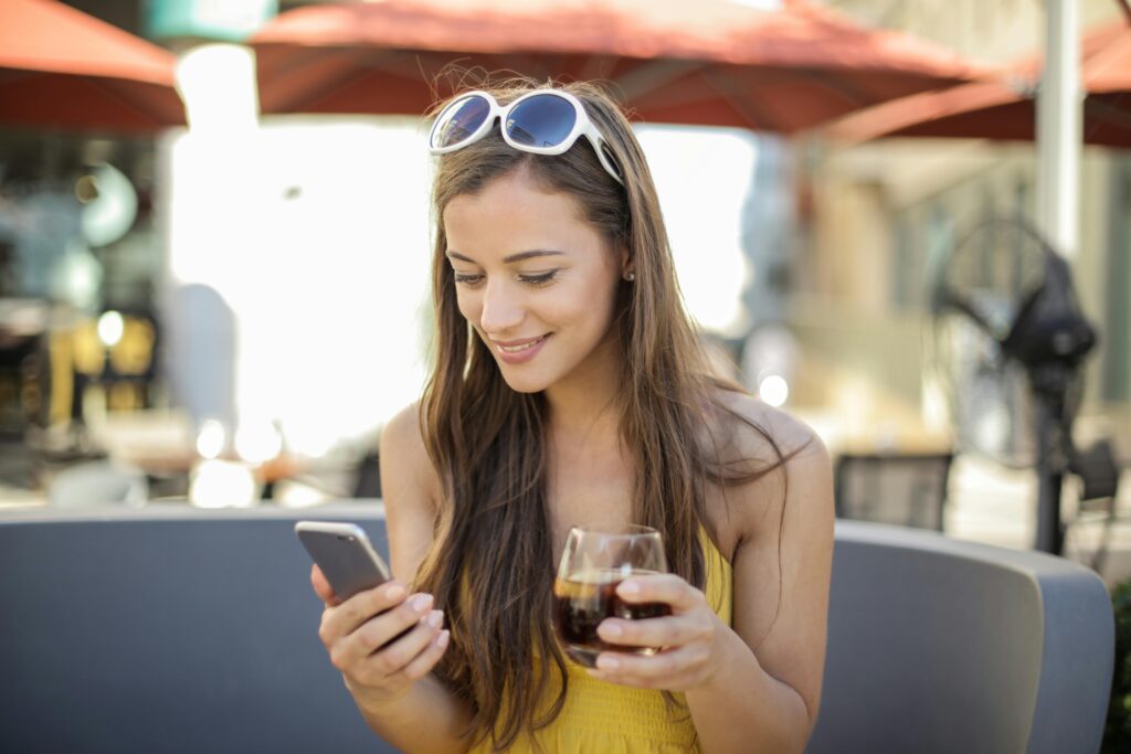 笑顔の女性 スマホ 飲物 海外 