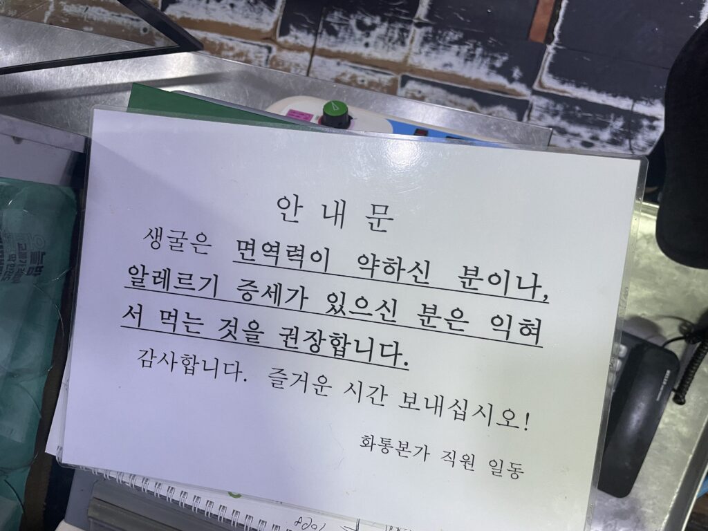 和通本家(화통본가/Hwatongbonga) 店内 お通し 牡蠣ポッサム 注意書き